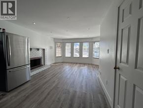 Vancouver apartment for rent - A spacious living room with wood flooring and a fireplace.