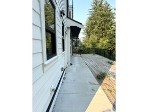 Chilliwack apartment for rent - A white building with a black fence and a black awning.