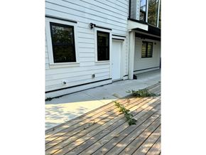 Chilliwack apartment for rent - A white house with a wooden deck in front.