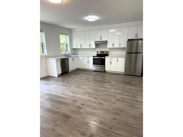 Chilliwack apartment for rent - A kitchen with white cabinets and a wooden floor.