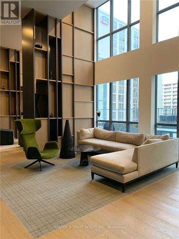 Toronto (Bay Street Corridor) condo for rent - A living room with a green chair and a white couch.