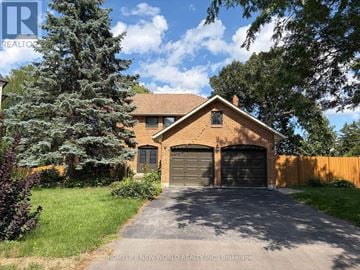 Aurora (Aurora Heights) apartment for rent - A house with a garage is surrounded by greenery and has a driveway leading to it.