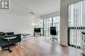 Toronto (Kensington-Chinatown) condo for rent - A living room with a green sofa and a black chair.