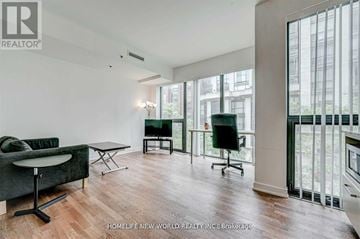 Toronto (Kensington-Chinatown) condo for rent - A living room with a green sofa and a black chair.