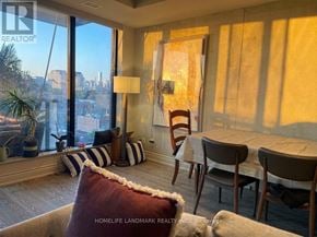 Toronto (Waterfront Communities) condo for rent - A living room with a view of the city through the windows.