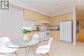 Toronto (Newtonbrook West) townhouse for rent - A modern kitchen with a glass table and white chairs.