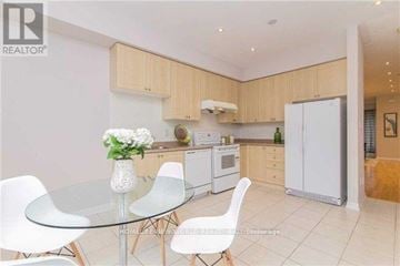Toronto (Newtonbrook West) townhouse for rent - A modern kitchen with a glass table and white chairs.