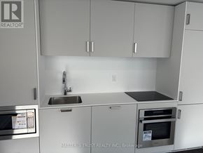 Toronto (Church-Yonge Corridor) condo for rent - A kitchen with white cabinets and a stainless steel sink.