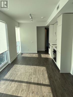 Toronto (Church-Yonge Corridor) condo for rent - A well-lit, spacious kitchen and living room with hardwood floors and white cabinetry.
