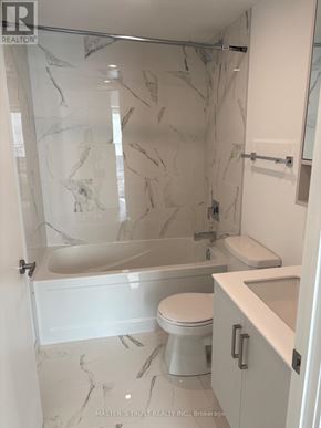 Toronto (Church-Yonge Corridor) condo for rent - A white bathroom with marble tiles and a glass shower stall.