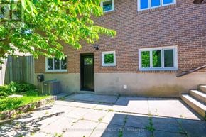 Toronto (Woburn) apartment for rent - A brick house with a green door and windows.