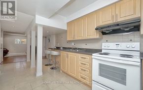 Toronto (Clairlea-Birchmount) apartment for rent - A modern kitchen with wooden cabinets and a white stove top oven.