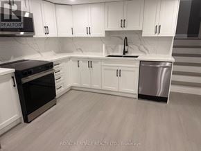 Oshawa (Donevan) apartment for rent - A kitchen with white cabinets and a black oven.