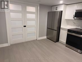 Oshawa (Donevan) apartment for rent - A kitchen with a white door, a fridge, and a microwave.