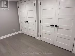 Oshawa (Donevan) apartment for rent - A white closet with a grey wall and a logo that says "REALTOR" on the top left.