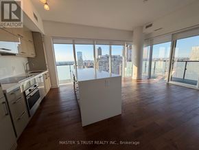 Toronto (Bay Street Corridor) condo for rent - A spacious kitchen and living room with a view of the city skyline.