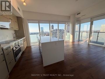 Toronto (Bay Street Corridor) condo for rent - A spacious kitchen and living room with a view of the city skyline.