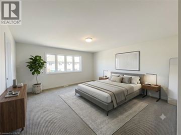 Ayr townhouse for rent - A well-lit bedroom with a large bed and a potted plant.