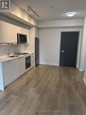 Toronto (Henry Farm) condo for rent - A kitchen with wooden floors and white cabinets.
