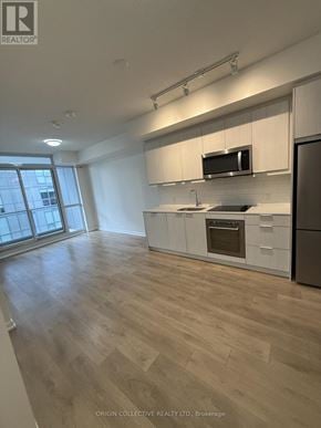 Toronto (Henry Farm) condo for rent - A kitchen with wooden floors and white cabinets.