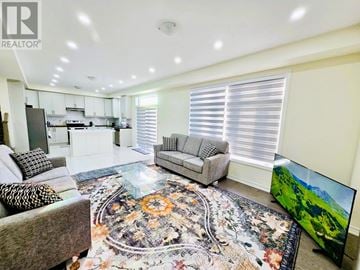 Georgina (Keswick South) apartment for rent - A living room with a grey sofa and a rug with a floral pattern.