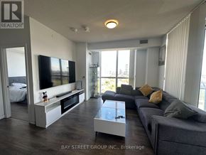 Toronto (Henry Farm) condo for rent - A living room with a grey couch and a television.