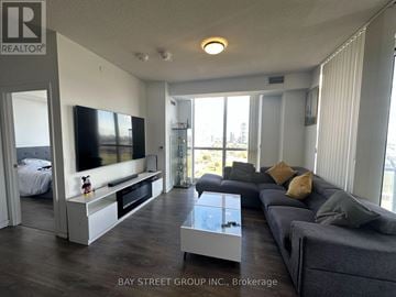 Toronto (Henry Farm) condo for rent - A living room with a grey couch and a television.