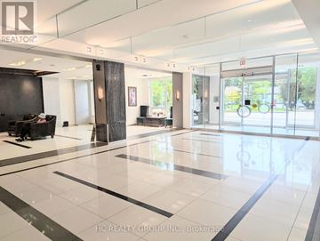 Markham (Grandview) condo for rent - A spacious lobby with a black and white floor and a glass wall.