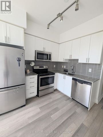 Markham (Grandview) condo for rent - A kitchen with white cabinets and a stainless steel refrigerator.