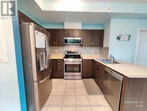 Oakville (Wm Westmount) townhouse for rent - A kitchen with a refrigerator, oven, and microwave.