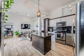Kitchener condo for rent - A modern kitchen with a wooden island in the middle.