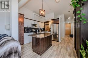 Kitchener condo for rent - A modern kitchen with a wooden island and stainless steel appliances.
