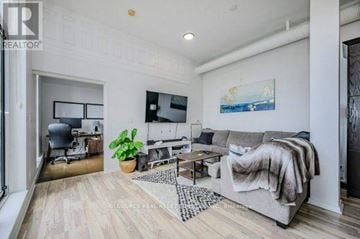 Kitchener condo for rent - A living room with a grey couch and a wooden floor.