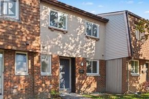 Ottawa townhouse for rent - A house with a brown brick wall and a grey garage door.