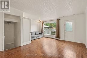 Ottawa townhouse for rent - A spacious room with wooden flooring and white walls.