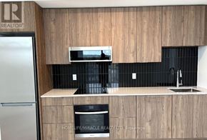Oakville (Ga Glen Abbey) condo for rent - A kitchen with wooden cabinets and a black oven.