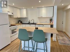 Collingwood apartment for rent - A kitchen with white appliances and green chairs.