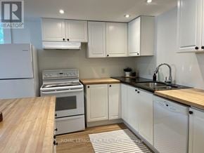 Collingwood apartment for rent - A kitchen with white cabinets and a wooden island.