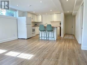 Collingwood apartment for rent - A kitchen with white appliances and a bar stool.