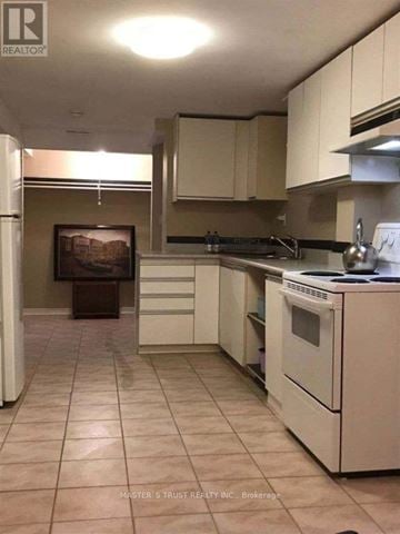 Mississauga (Erindale) apartment for rent - A kitchen with white appliances and brown cabinets.