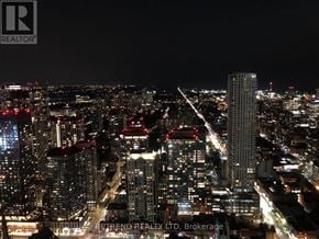 Toronto (Church-Yonge Corridor) condo for rent - A cityscape at night with a dark sky.