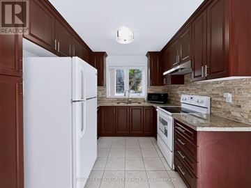 Newmarket (Woodland Hill) apartment for rent - A kitchen with brown cabinets and a white refrigerator.