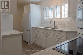 Hamilton (Inch Park) multi-family for rent - A kitchen with white appliances and cabinets.