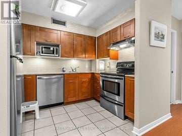 Toronto (Thorncliffe Park) condo for rent - A kitchen with wooden cabinets and stainless steel appliances.