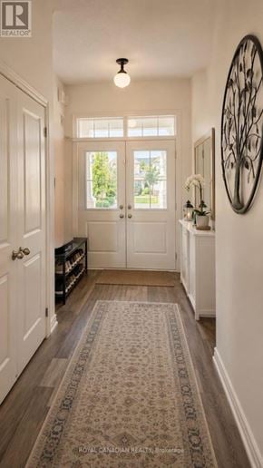 Clarington (Bowmanville) townhouse for rent - A hallway with a rug on the floor and a round mirror on the wall.