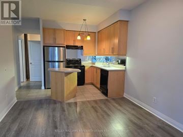 Toronto (Bay Street Corridor) condo for rent - A kitchen with wooden cabinets and a stainless steel refrigerator.