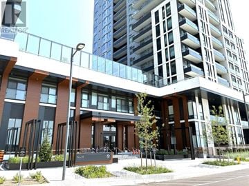 Vaughan (Vaughan Corporate Centre) condo for rent - A modern building with a glass facade and a brown entrance.