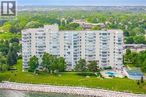Burlington condo for rent - A large apartment building with a pool and tennis court in front.