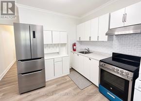 Toronto (The Beaches) apartment for rent - A kitchen with white cabinets and a stainless steel refrigerator.