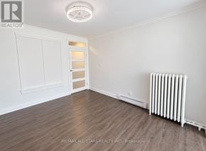 Toronto (The Beaches) apartment for rent - A room with a white ceiling light, a white door, and a white radiator on the wall.